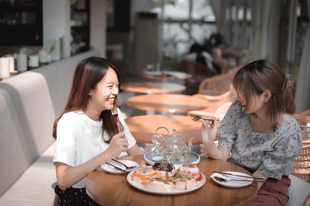 Two guests enjoying brunch together inside Ryoku Cafe